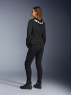 Alpinestars Daisy V3 dames motorjeans, motorbroek voor dames, Rinse Black, achteraanzicht met slanke pasvorm en hoge taille, gecombineerd met een zwarte Alpinestars hoodie en motorschoenen voor een urban motorlook