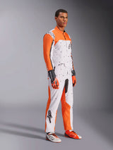 Alpinestars KMX-9 V3 Graphic 6 Karting Suit, White Orange and Black, featuring a speckled pattern and vibrant orange sleeves, worn by a model with matching racing gloves and shoes, professional dual-layer motorsport gear.