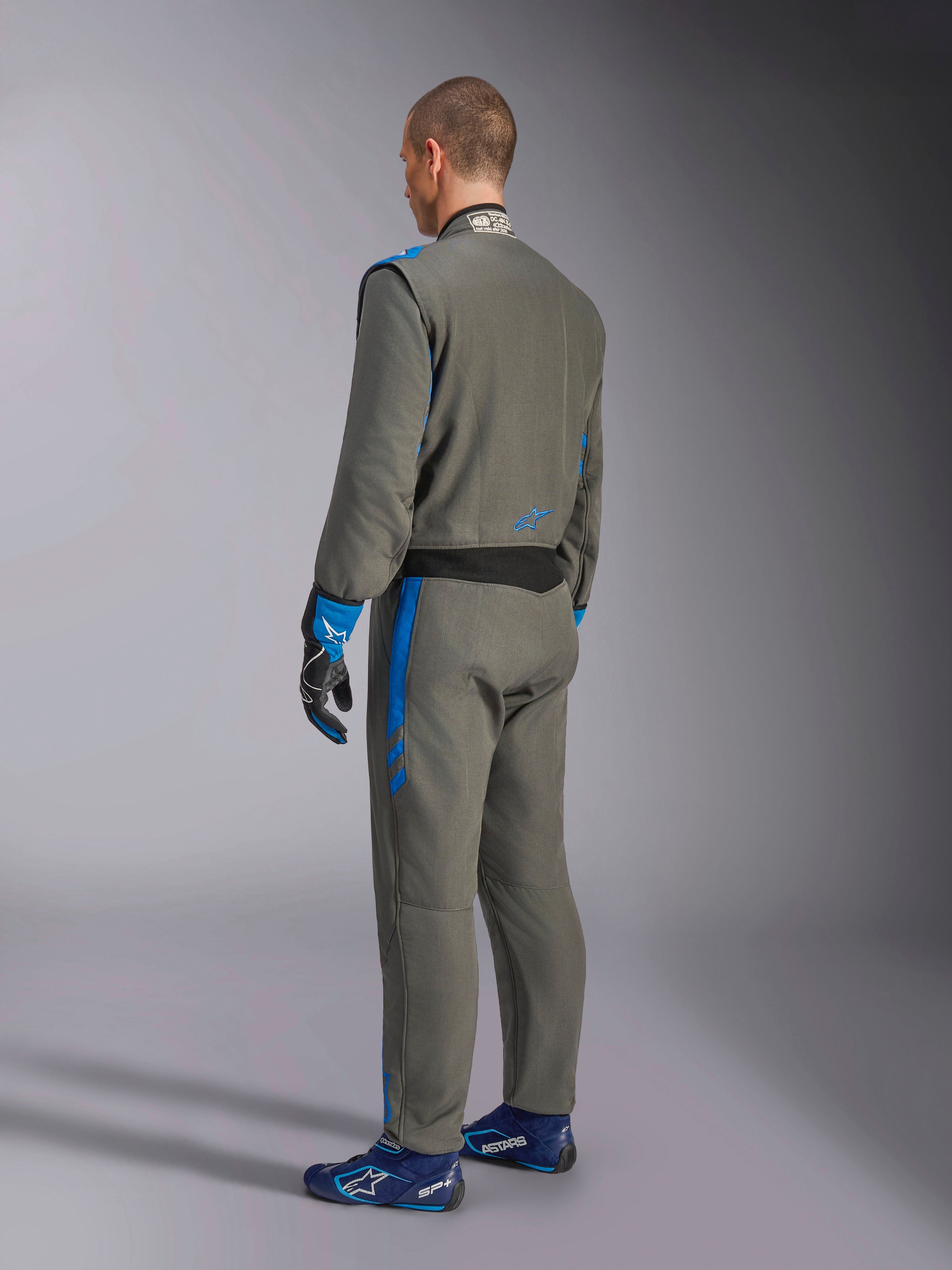Alpinestars GP Race V3 Suit FIA, Auto Racing Suit, Anthracite Blue, rear view of model wearing the grey one-piece suit with blue accents, matching blue gloves and racing shoes, professional motorsport gear design