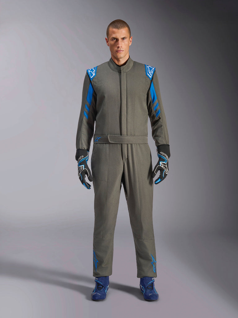 Alpinestars GP Race V3 Pak FIA, antracietblauw autoracepak, gedragen met bijpassende handschoenen en raceschoenen, voorzien van helderblauwe schouderepauletten en mouwstrepen, Alpinestars logo-details, professionele motorsportbescherming voor circuitwedstrijden