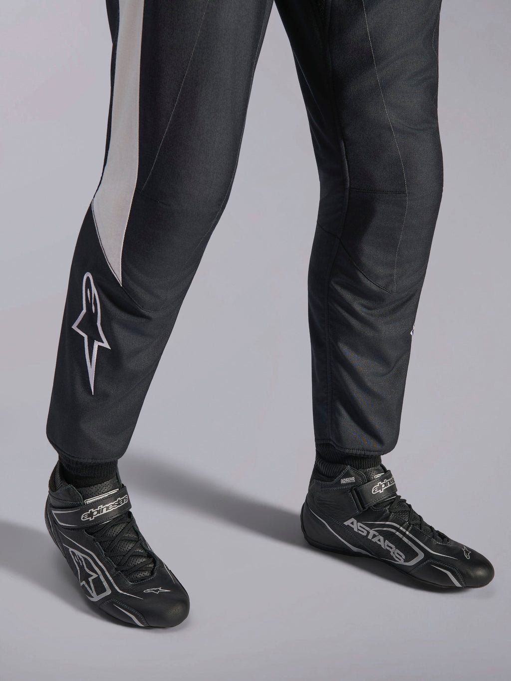 Alpinestars GP Pro Comp V2 FIA-pak, zwart en wit autoracepak met bijpassende professionele ASTARS-raceschoenen.