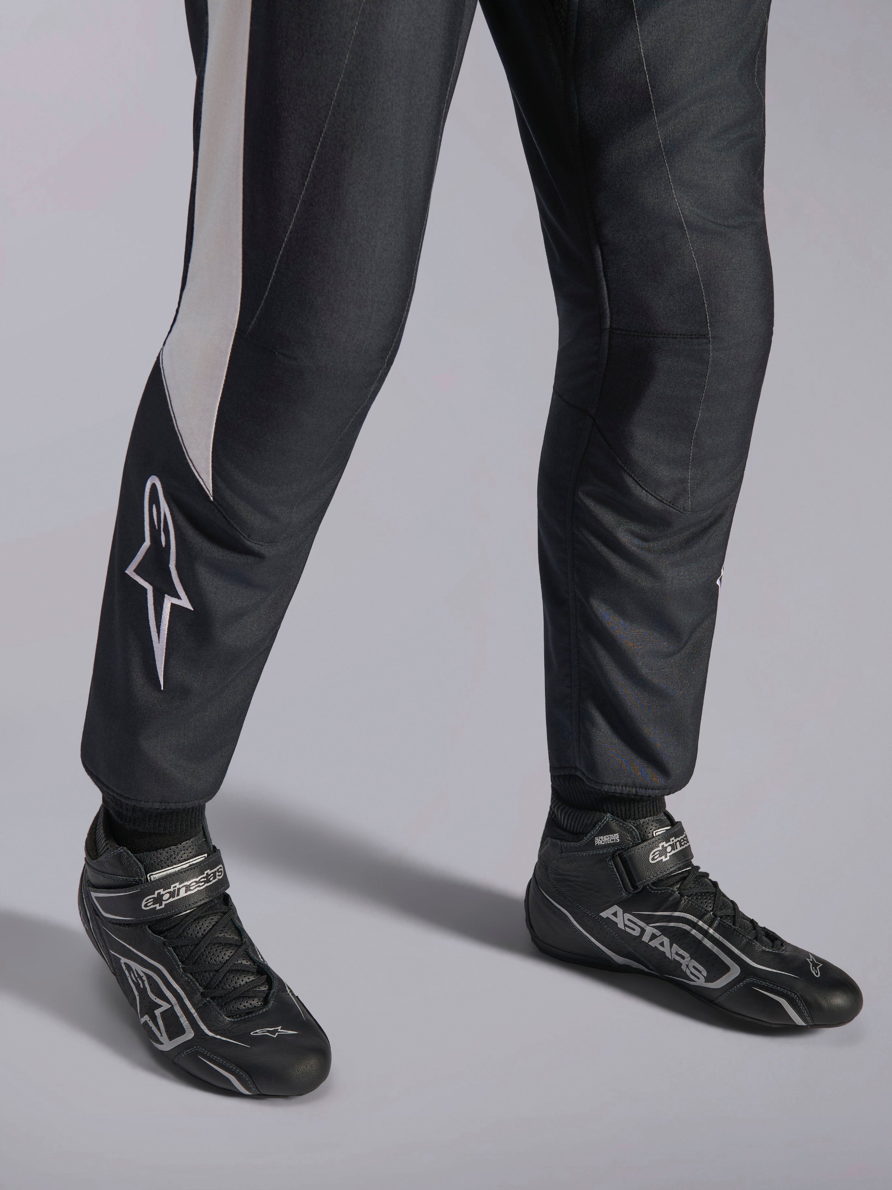 Alpinestars GP Pro Comp V2 FIA-pak, zwart en wit autoracepak met bijpassende professionele ASTARS-raceschoenen.