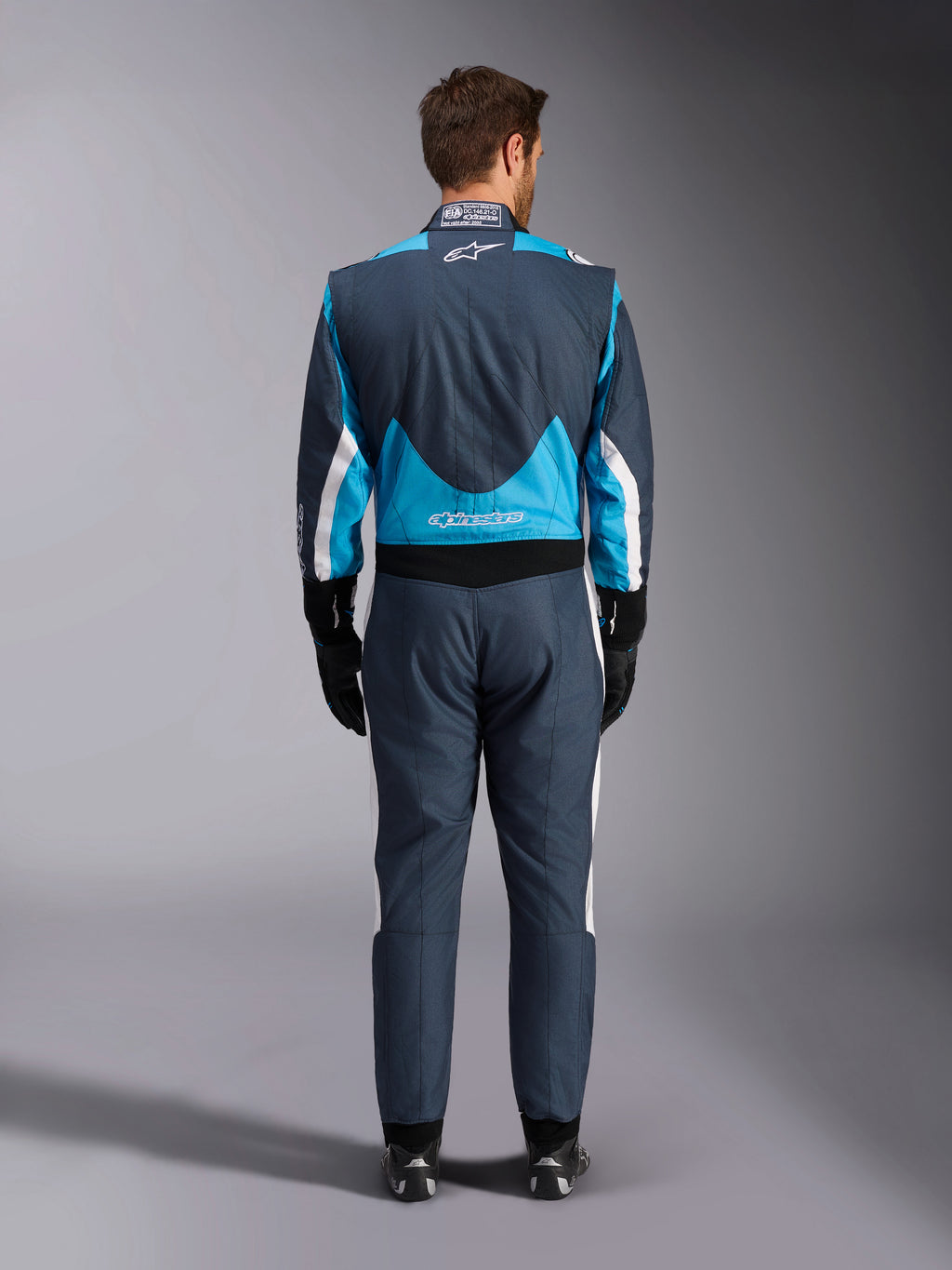 Alpinestars GP Pro Comp V2 FIA heren-autoracepak, grijs en cyaanblauw, achteraanzicht, professionele racebescherming.