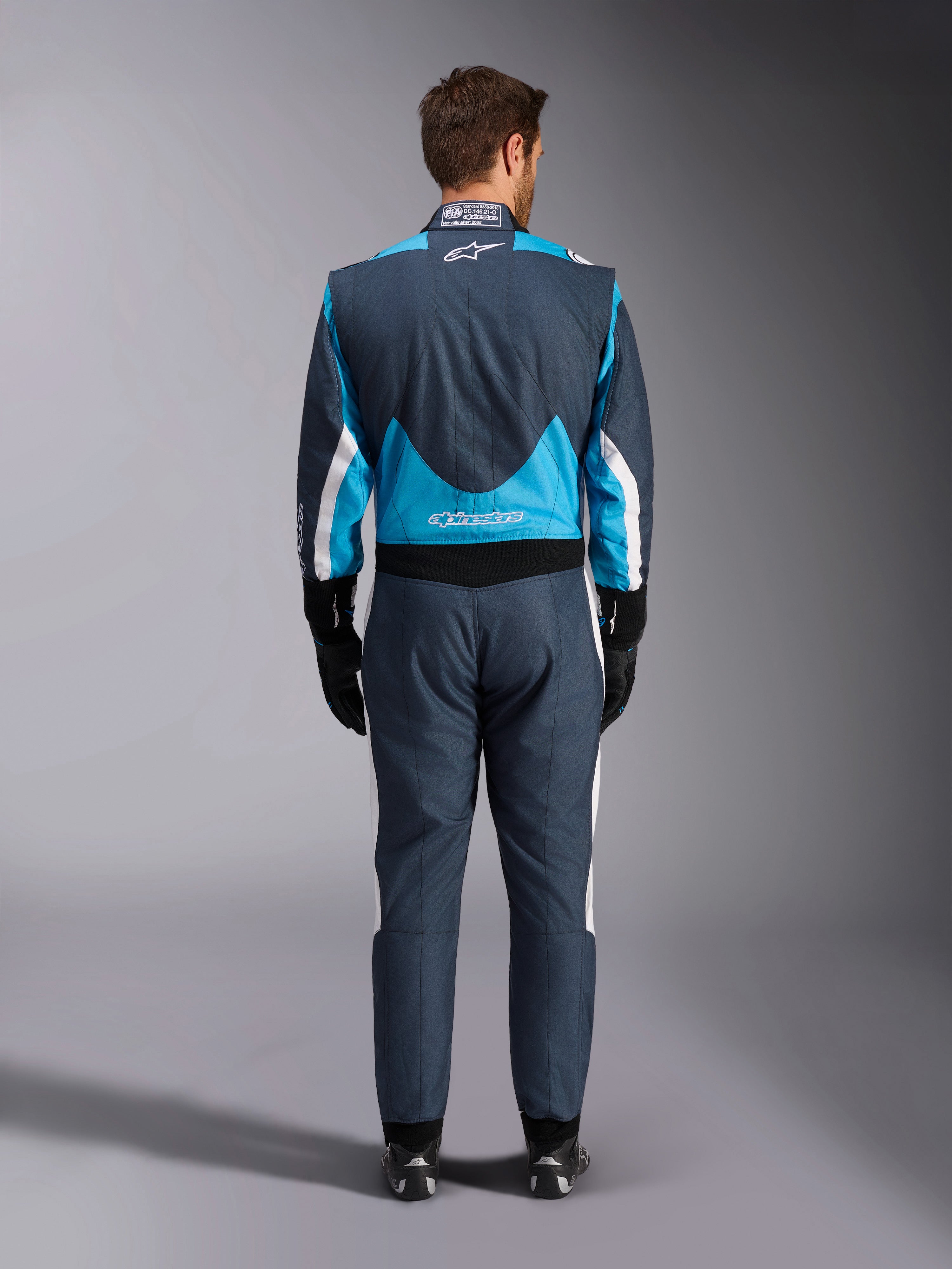 Alpinestars GP Pro Comp V2 FIA heren-autoracepak, grijs en cyaanblauw, achteraanzicht, professionele racebescherming.