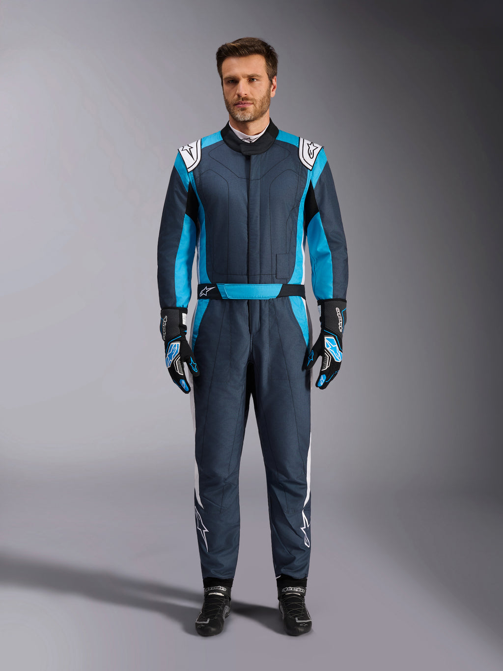 Alpinestars GP Pro Comp V2 pak, FIA-gecertificeerd racepak voor heren, asfaltgrijs en cyaanblauw met witte accenten.