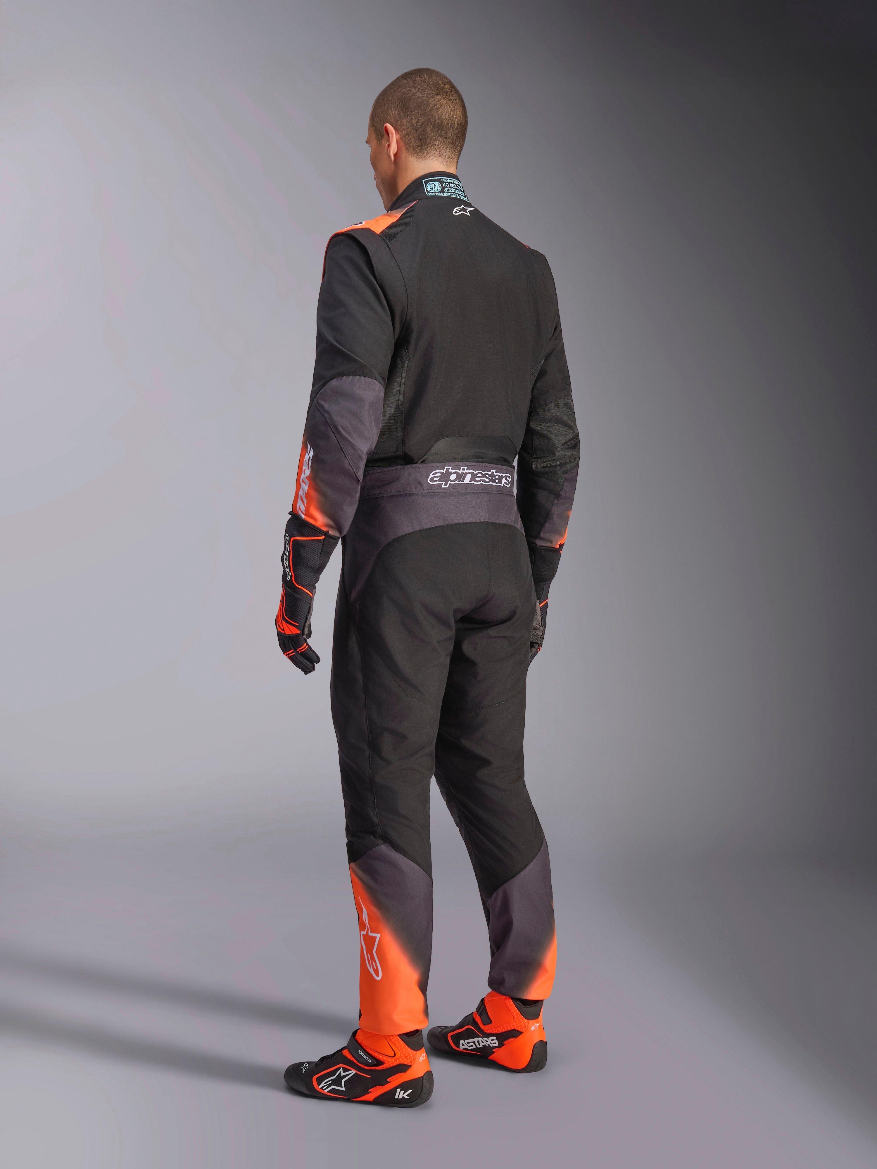Alpinestars KMX-5 V3 kartpak, herenmodel in zwart en oranje fluo, achteraanzicht, FIA 8877-2022 Grade 1 gecertificeerd.