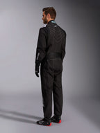 Alpinestars KMX-9 V3 Suit, Black and White Karting Suit, rear three-quarter view on a male model, featuring white contrast stitching, stretch panels on the back and shoulders, white brand logos, worn with black racing gloves and black shoes with red soles.