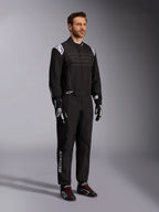 Alpinestars KMX-9 V3 Karting Suit, Black and White, male model wearing full racing suit with white Alpinestars logo on epaulettes, paired with black and white racing gloves and black karting shoes with red laces, studio shot showing the front and side profile