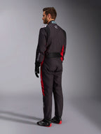 Alpinestars KMX-9 V3 Graphic 3 Suit, zwart en rood, achteraanzicht van model in volledige kartuitrusting inclusief zwarte handschoenen en raceschoenen, met rode zijpanelen en witte logodetails