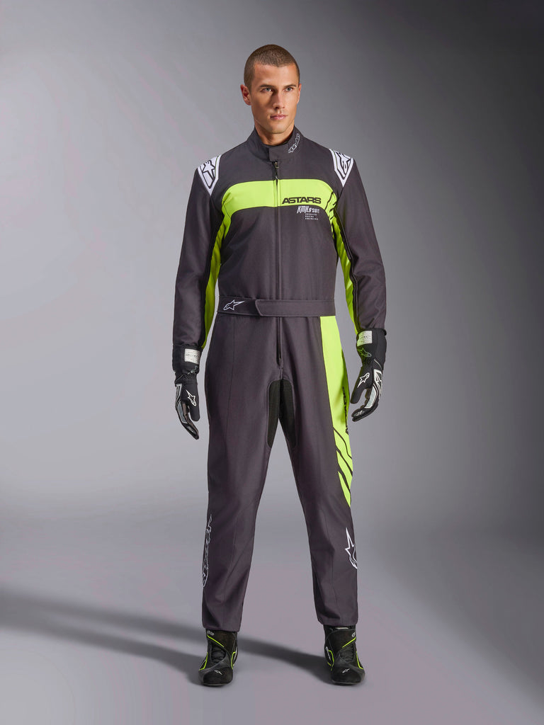 Alpinestars KMX-9 V3 Graphic 3 Suit, zwart en fluogeel, professioneel eendelig kartpak gedragen door een model, met opvallende neongele accenten, ASTARS-branding op de borst en bijpassende racehandschoenen en laarzen.