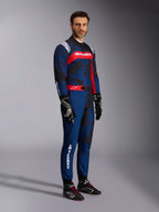 Alpinestars KMX-9 V3 Graphic 5 kartpak in Navy Red, marineblauw met donkere camouflage-graphics en een opvallend rood borstpaneel met witte branding, volledig lichaamsbeeld inclusief zwarte karthandschoenen en zwarte raceschoenen, professionele beschermende kartuitrusting