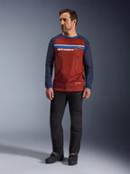 Alpinestars Maxdura Dual Jersey, Rust Brown en Mood Indigo, adventure motorjersey met een mesh-torso en navy mouwen, gedragen door een model met zwarte rijbroek en zwarte laarzen, technische dual-sport kleding voor off-road rijden