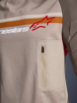 Alpinestars Maxdura Dual Jersey, Aluminum Walnut, detailopname van de mesh torso, horizontale oranje en witte streep met rood logo, verticale borstzak met ritssluiting, adventure motorkleding