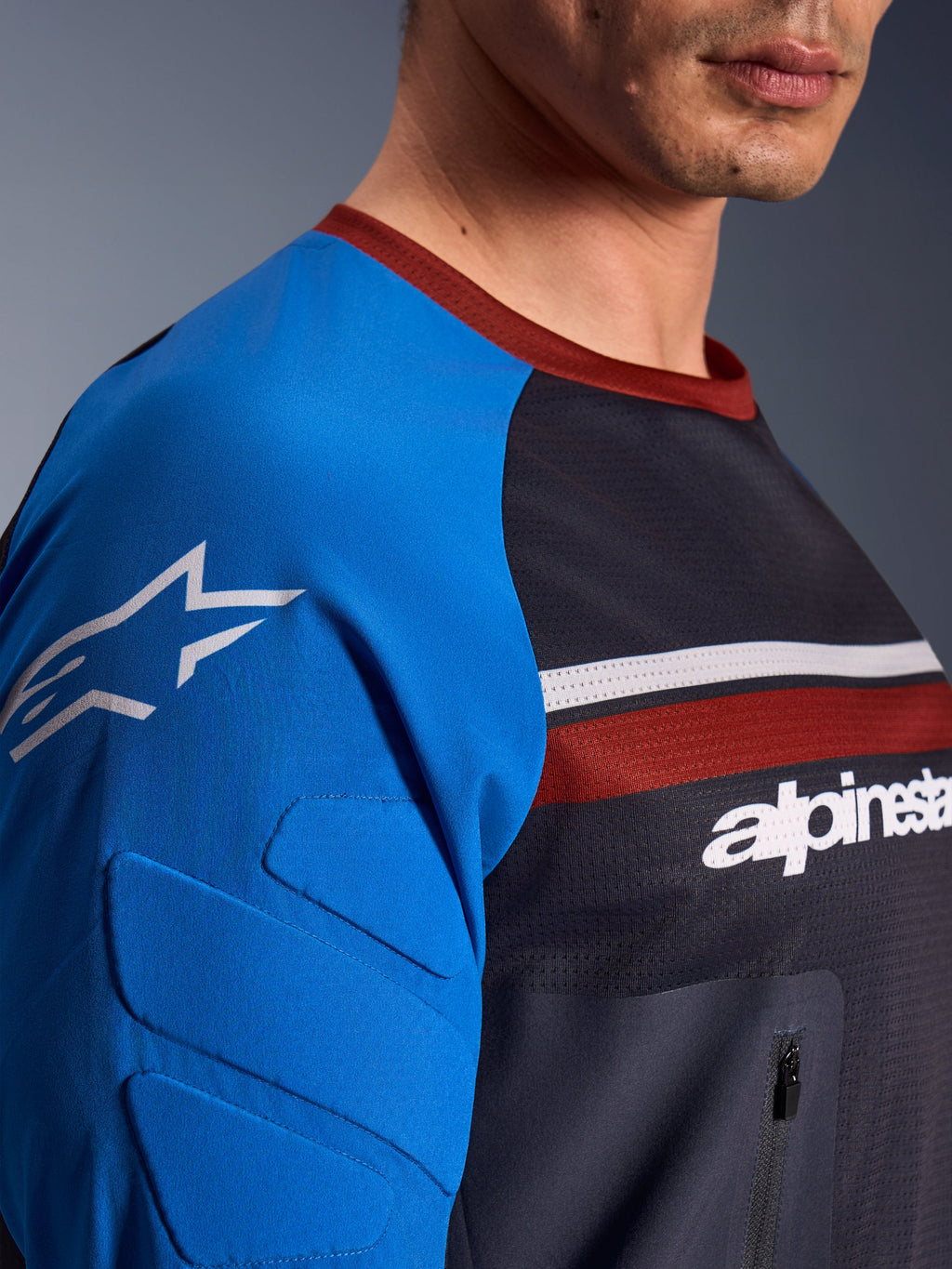 Alpinestars Maxdura Dual Jersey, motorjersey, donkergrijs en koningsblauw, detailopname van borstzak met ritssluiting, mesh materiaal op de romp en geïntegreerde mouwvulling met sterlogo