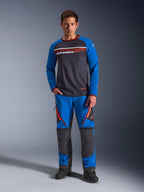 Alpinestars Maxdura Dual Jersey, motor jersey, donkergrijs en koningsblauw, volledige mesh torso met gewatteerde mouwen en borstzakken met rits, voorzien van wit en oranje Alpinestars-logo, gedragen met bijpassende adventure broek en zwarte laarzen