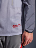 Alpinestars Maxdura Dual Jersey, middengrijs en donkergrijs, close-up van de ademende mesh torso met rode branding, detail van de zak met ritssluiting en geïntegreerde padding op de mouw, technische adventure motorkleding