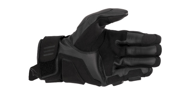 A black and white Alpinestars EU Phenom Leather Glove displaying the palm side, highlighting protective knuckle padding, perforated leather for breathability, and a Velcro strap at the wrist for a secure fit. The Alpinestars logo is visible on the side of these sport performance gloves.