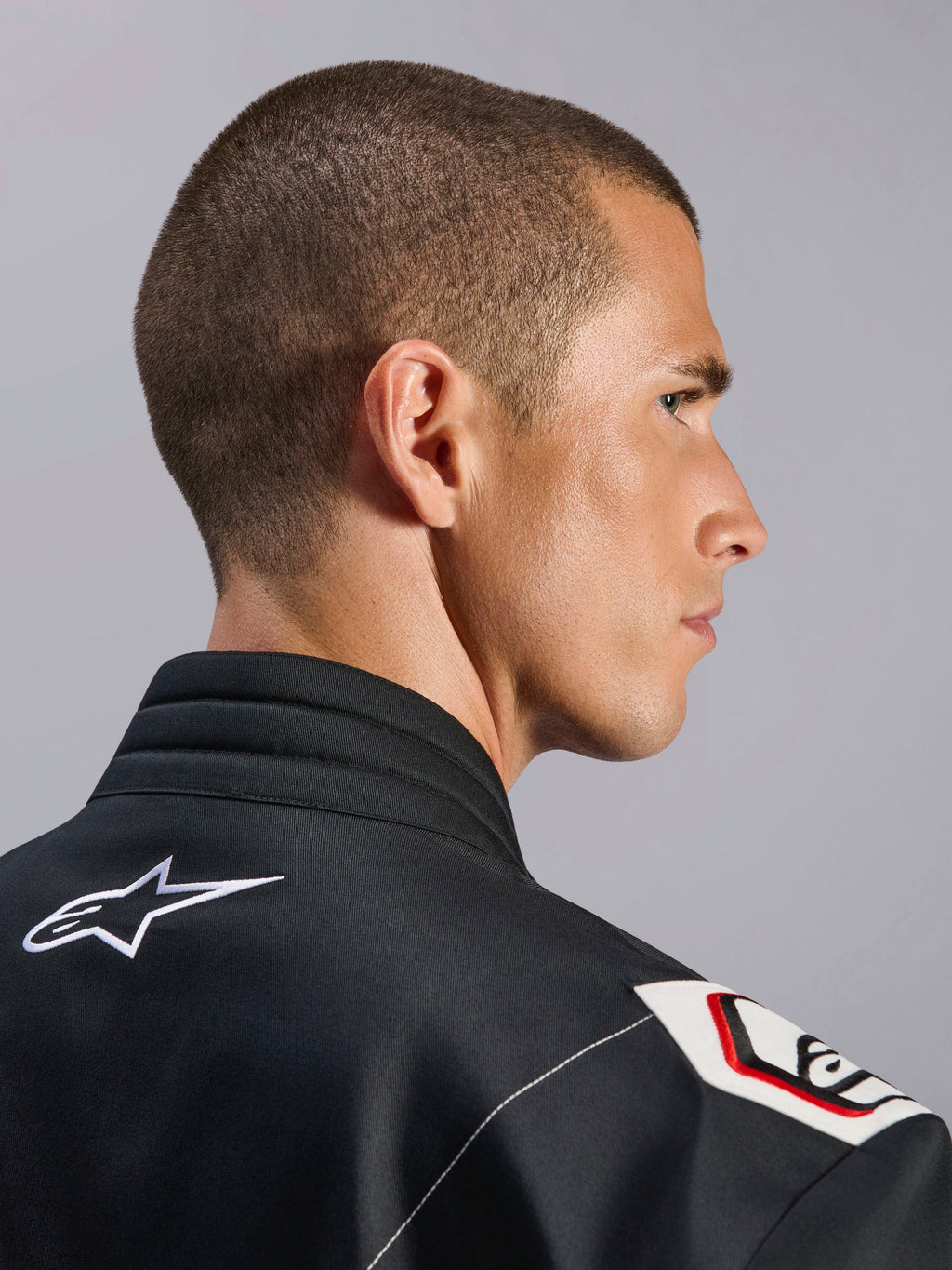 Alpinestars Kart Indoor V2-pak, zwart, close-up van de ergonomische kraag en het op Formule 1 geïnspireerde schouderontwerp, met wit Alpinestars-logo en op racen geïnspireerde details op duurzame keperstof