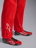Alpinestars Kart Indoor V2 Pak, rood, detail van het onderbeen met wit geborduurd sterlogo, gedragen met bijpassende rood-zwarte kartingschoenen, enkellaags poly-katoen keperstof materiaal voor recreatief racen
