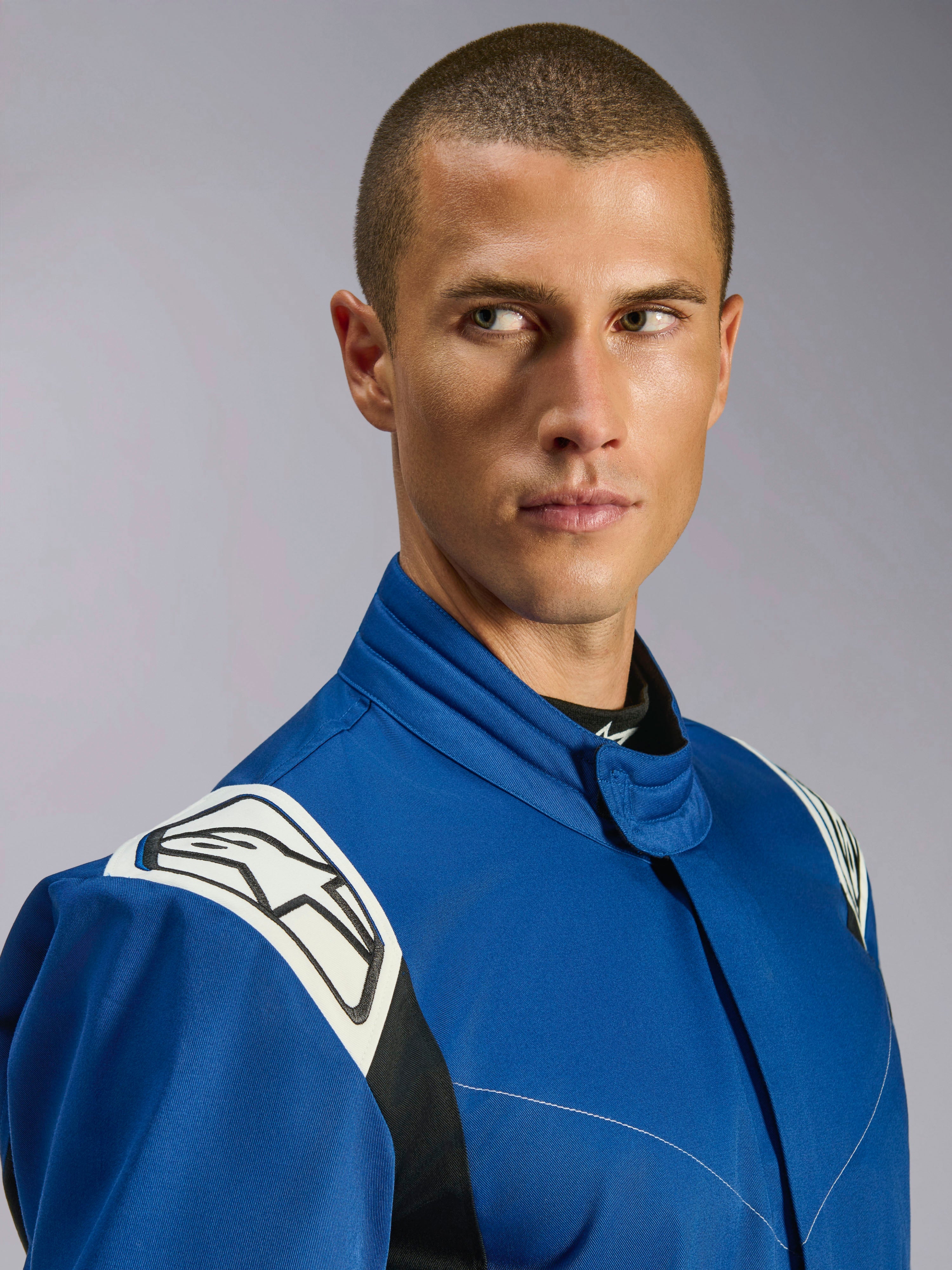 Alpinestars Kart Indoor V2 Pak, blauw kartpak, close-up van mannelijk model, witte schouderpanelen met zwart sterlogo, ergonomische kraag, duurzame enkellaagse keperstof voor recreatief racen.