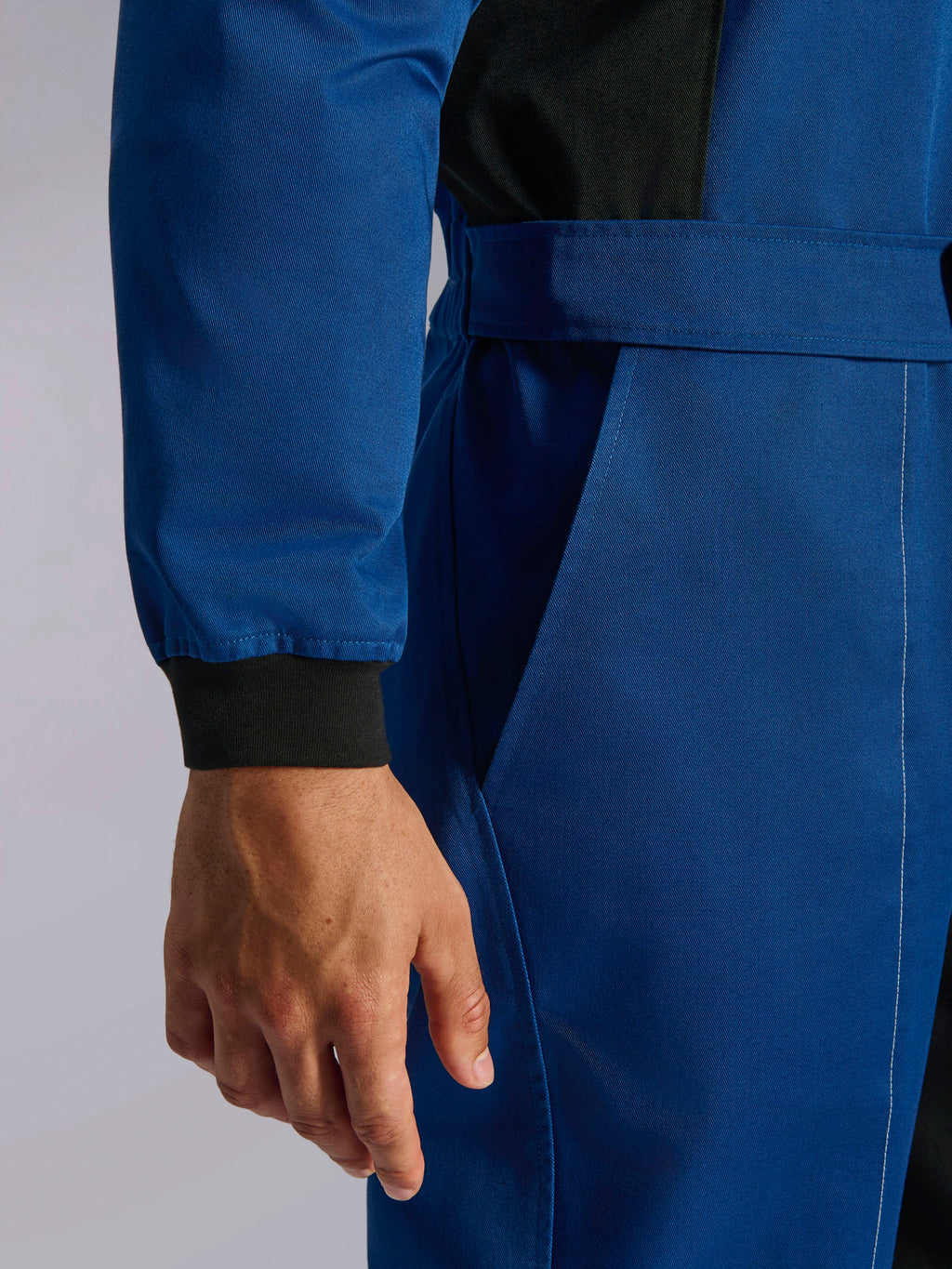 Alpinestars Kart Indoor V2-pak, blauw kartingpak, close-up detail van de verstelbare tailleband en gebreide polsboord, duurzame poly-katoen keperstof met zwarte accenten en functionele zak