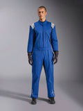 Mannelijk model in een blauw Alpinestars Kart Indoor V2-pak, eendelig kartpak met witte sterlogo's op schouders en schenen, witte contraststiksels en een elastische tailleriem, gestyled met zwarte racehandschoenen en schoenen, ontworpen voor recreatief circuitgebruik