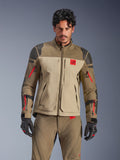 Alpinestars Nazca 3L GORE-TEX PRO jas, adventure motor touringjas, walnootbruin en beige met rode accenten, voorzien van zwarte Superfabric-schouderversterkingen en rode ritsen op de mouwen, gedragen door een rijder met bijpassende uitrusting, premium technische adventure kleding