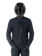 Alpinestars St-7 Prime GORE-TEX jas, zwarte motor touringjas, waterdicht en ademend, ritssluiting aan de voorzijde, meerdere zakken, gedragen met bijpassende helm en handschoenen, premium bescherming voor rijden in alle weersomstandigheden