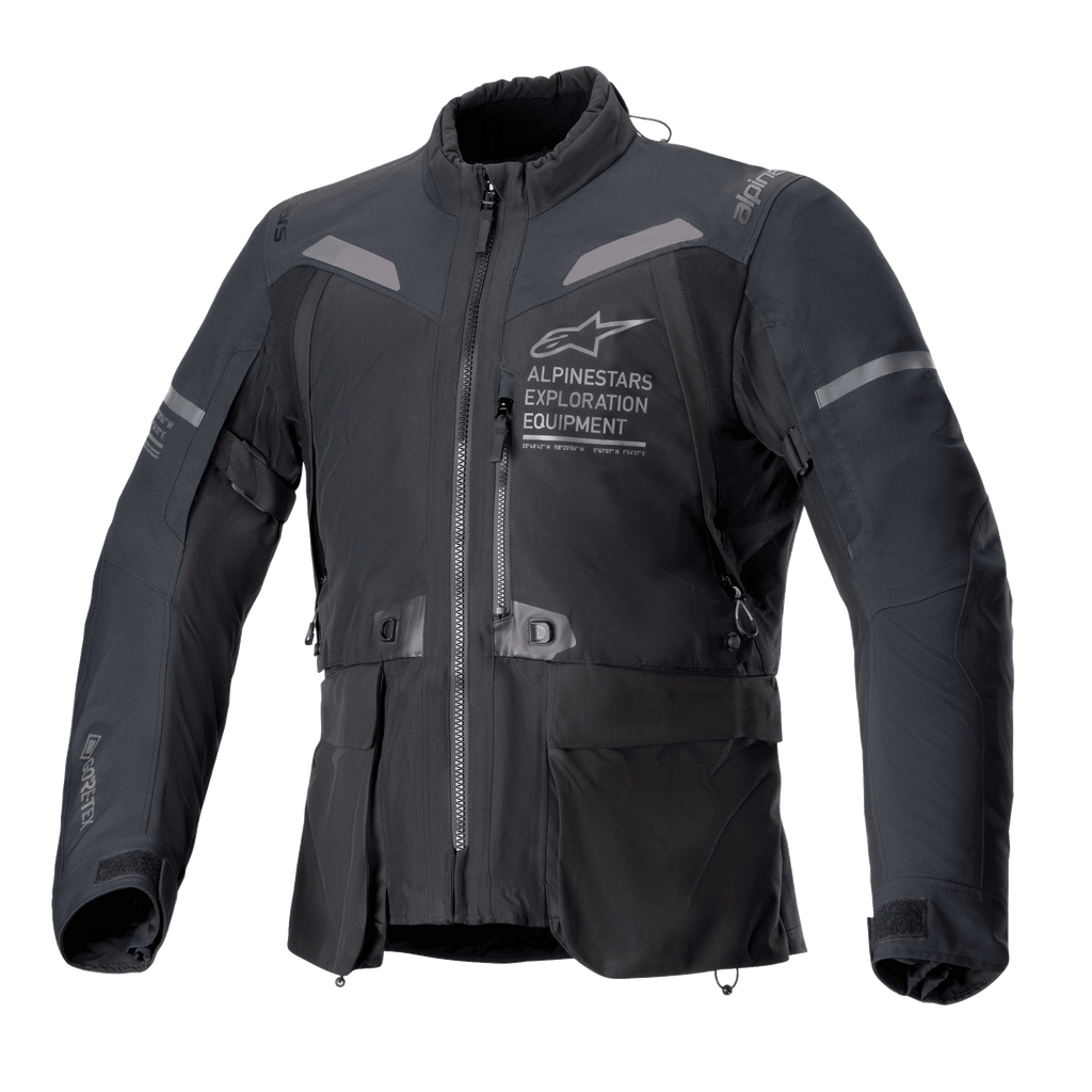 Alpinestars ST-7 2L GORE-TEX Jas, motorjas in zwart en donkergrijs, vooraanzicht met grote cargozakken, reflecterende accenten op de schouders en Alpinestars Exploration Equipment-logo op de borst, waterdichte adventure touring-uitrusting