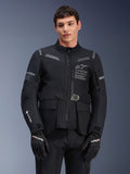 Alpinestars ST-7 2L GORE-TEX jas, touring motorjas, zwart en donkergrijs, voorzien van Alpinestars Exploration Equipment-branding op de borst, grote waterdichte cargozakken, GORE-TEX-logo op de mouw, robuust adventure-ready ontwerp met reflecterende accenten