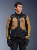 Alpinestars ST-7 2L GORE-TEX motorjas, adventure touring motorjas, Gobi Brown en zwart met oranje accenten, gedragen door een mannelijk model, voorzien van Exploration Equipment-branding en GORE-TEX-technologie, duurzame waterdichte motoruitrusting.