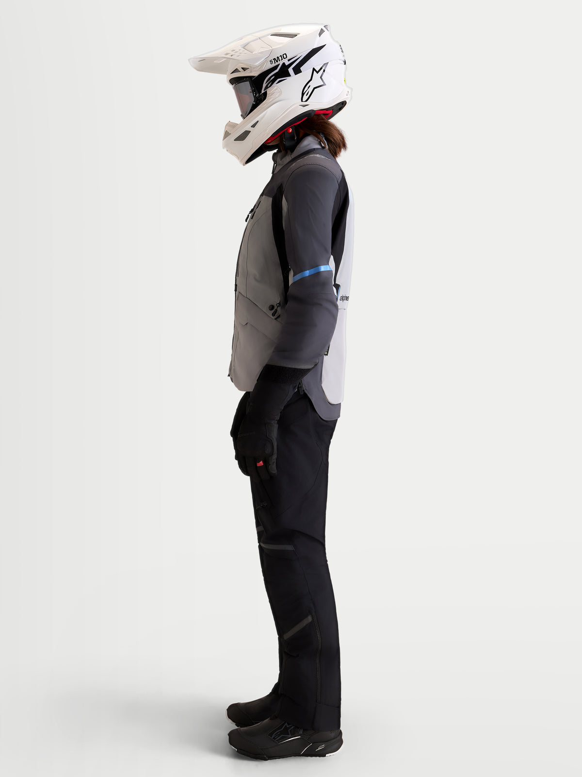 Alpinestars Stella ST-7 V2 2L Gore-Tex Jacket, women's adventure touring motorcycle jacket in mid gray, deep gray, and black, side profile view on a model wearing a matching helmet and riding gear.