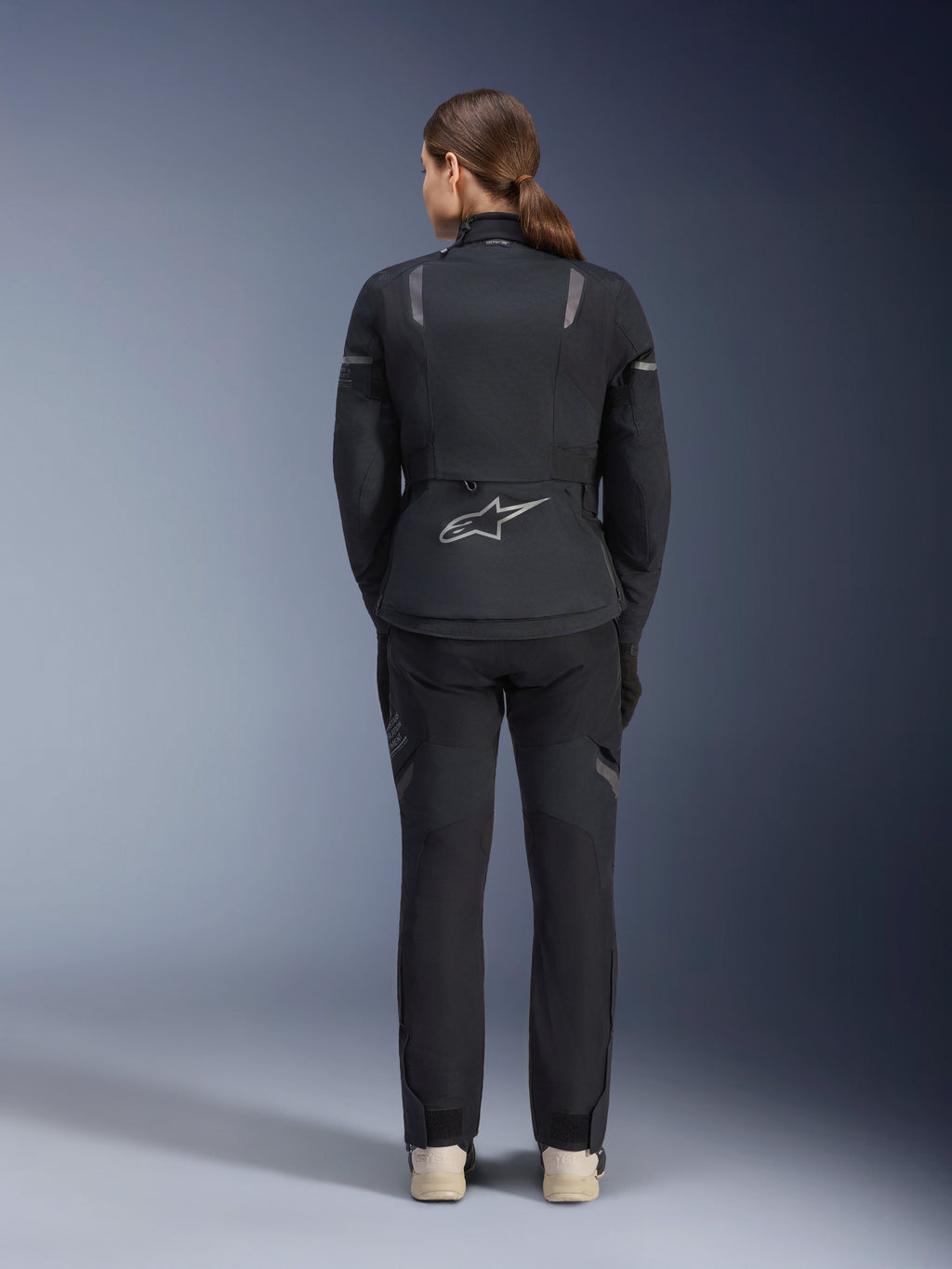 Alpinestars Stella ST-7 2L GORE-TEX jas en broek, adventure touring motoroutfit voor dames, zwart en donkergrijs, achteraanzicht met het Astar-logo en reflecterende details, duurzame waterdichte textielconstructie