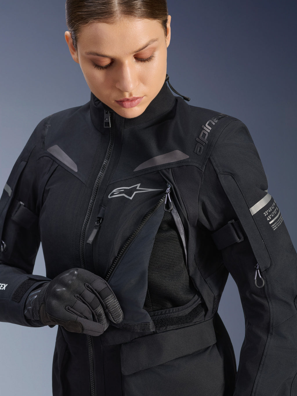 Alpinestars Stella ST-7 2L GORE-TEX damesjas in zwart donkergrijs, detailweergave van het borstventilatiepaneel geopend om de mesh voering te onthullen, met het Alpinestars logo en branding op de schouder, ontworpen voor adventure road-touring.