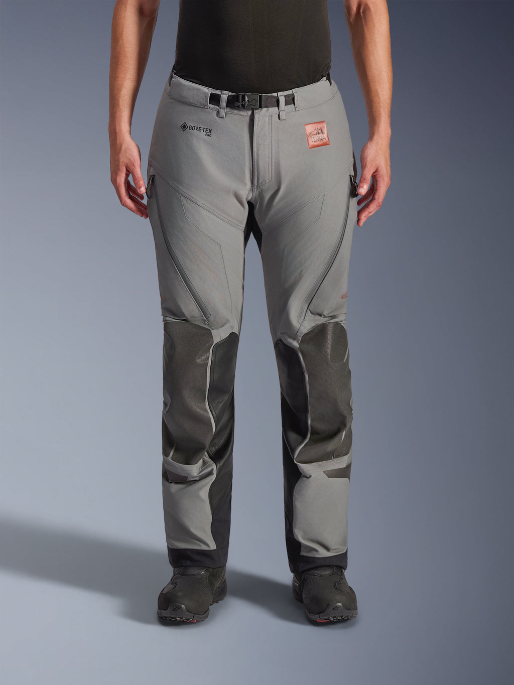 Alpinestars Nazca 3L GORE-TEX PRO broek, grijs met zwarte knie- en scheenbeenversterkingen, technische adventure motorbroek, vooraanzicht, met GORE-TEX-branding, ventilatieopeningen met rits op de bovenbenen en verstelbare tailleriem