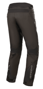 Alpinestars Road Pro GORE-TEX broek, zwarte motorbroek, achteraanzicht met taps toelopende touring-pasvorm, technische textielconstructie, Alpinestars-branding op het onderbeen, accordeon stretchpanelen en verstelbare banden voor adventure touring.