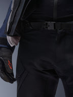 Alpinestars ST-7 2L GORE-TEX broek, zwart, close-up van de taille met een magnetische gespsluiting en duurzame technische textielconstructie, gedragen met bijpassende adventure touring-jas en zwarte handschoenen met een rood logo.