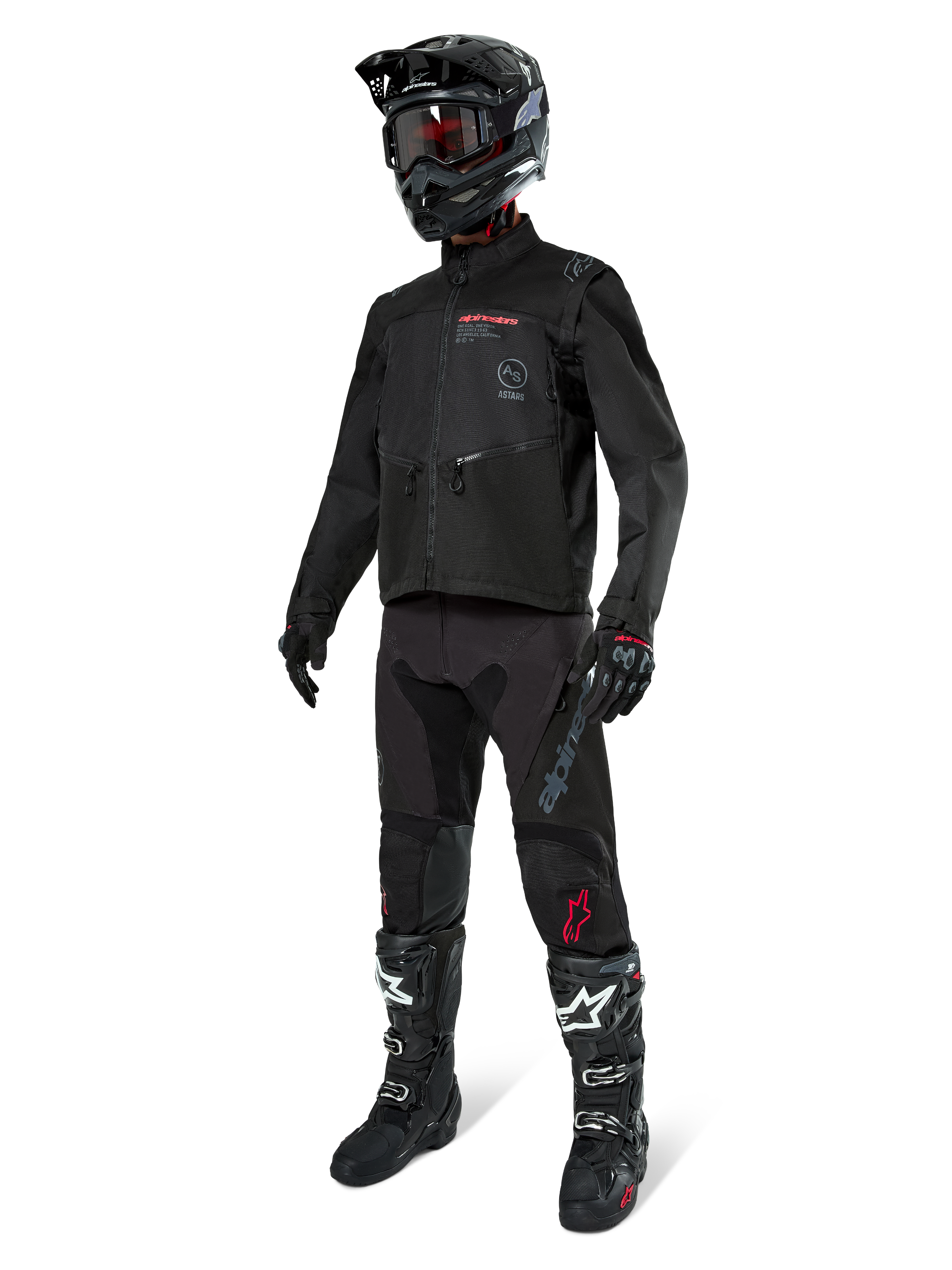 Motocross rider wearing complete racing gear, Alpinestars Pro-Dura Jacket in Black, black pants with grey branding and red accents, black helmet with goggles, and black and white motocross boots, coordinated outfit for enduro and off-road riding