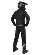 Alpinestars Pro-Dura Jacket, Black Off-road Enduro Jacket, rear view worn with matching pants and black Tech 10 boots, featuring prominent Alpinestars branding on the lower back, rugged textile construction for aggressive trail riding