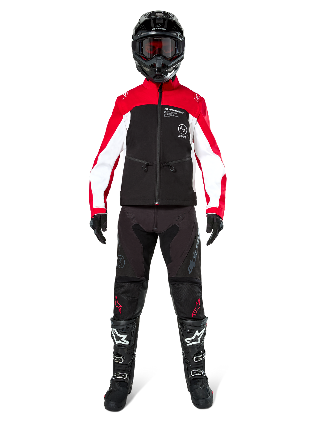 Motorcrosser in Alpinestars Lite-Dura Softshell Jas in zwart, felrood en wit, gecombineerd met een zwarte off-road broek, zwart-witte laarzen en een zwarte helm met crossbril, complete uitrusting voor enduro racing