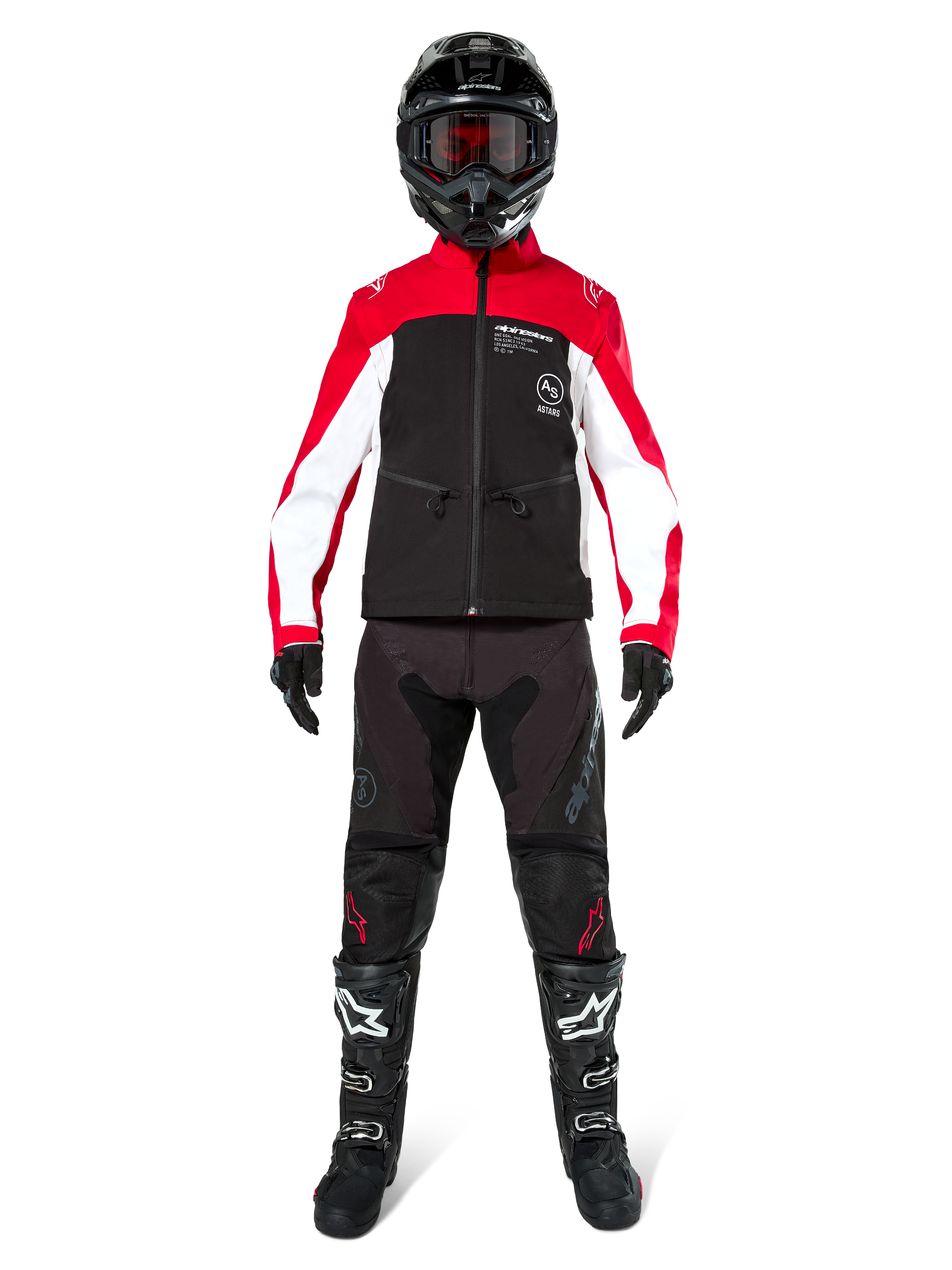 Motorcrosser in Alpinestars Lite-Dura Softshell Jas in zwart, felrood en wit, gecombineerd met een zwarte off-road broek, zwart-witte laarzen en een zwarte helm met crossbril, complete uitrusting voor enduro racing