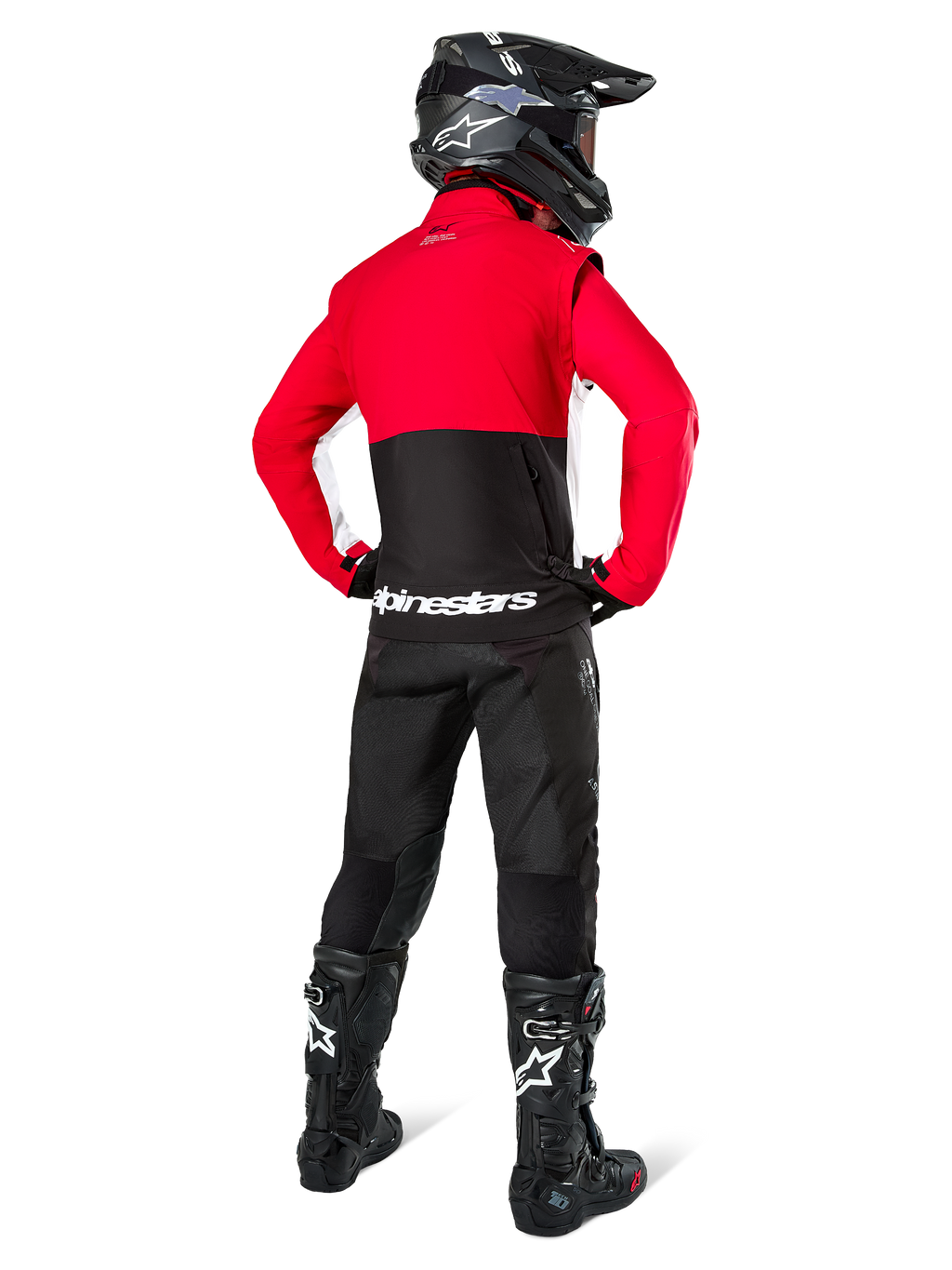 Motorcrosser van achteren gezien in Alpinestars Lite-Dura Softshell Jas, Zwart Felrood en Wit, met een rood bovenpand en een zwart ondergedeelte met witte logo's, gecombineerd met een zwarte broek, zwarte helm en zwarte laarzen, gecoördineerde enduro-outfit voor off-road rijden