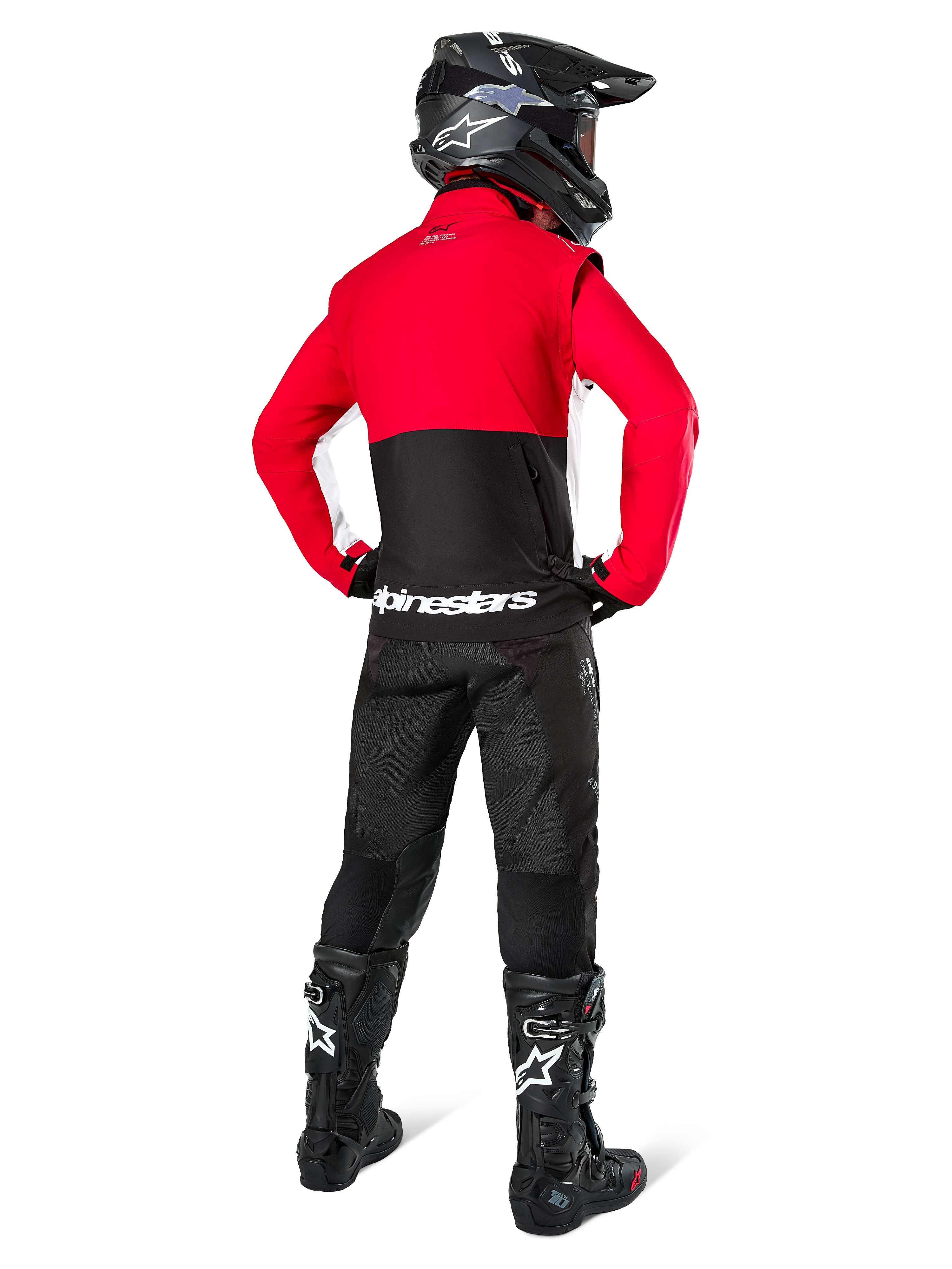 Motorcrosser van achteren gezien in Alpinestars Lite-Dura Softshell Jas, Zwart Felrood en Wit, met een rood bovenpand en een zwart ondergedeelte met witte logo's, gecombineerd met een zwarte broek, zwarte helm en zwarte laarzen, gecoördineerde enduro-outfit voor off-road rijden