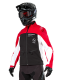 Alpinestars Lite-Dura Softshell Jacket, motorjas, zwart, felrood en wit, gedragen door een rijder met een zwarte motorcrosshelm, rode bril en handschoenen, opvallende branding op de borst, ontworpen voor off-road en enduro rijden
