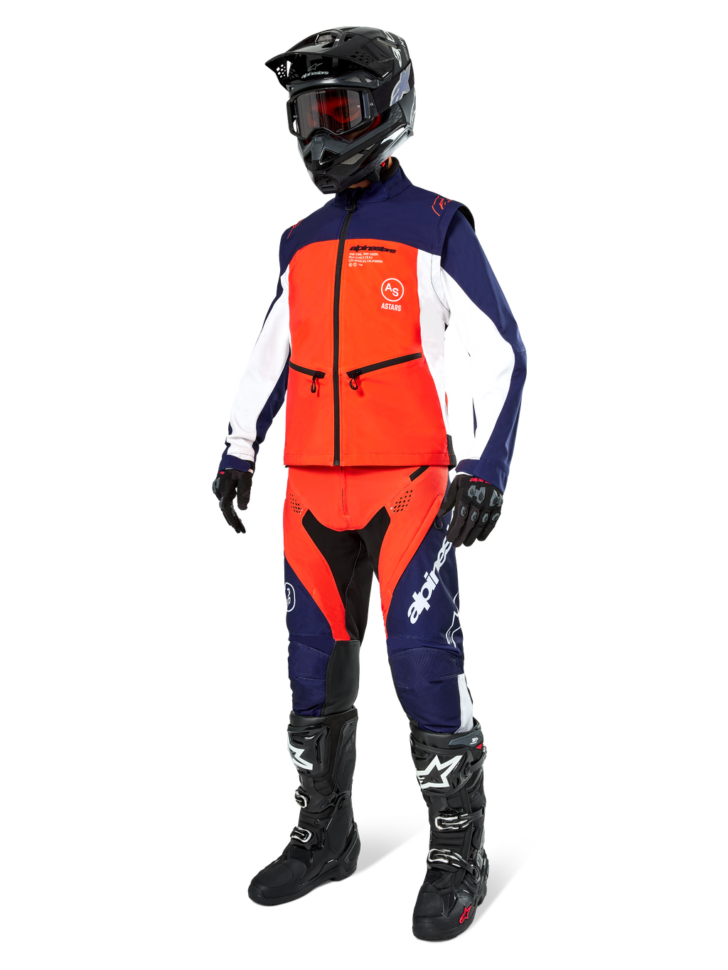 Motorcrossrijder in de Alpinestars Lite-Dura Softshell Jas in Navy Hot Orange en wit, compleet met bijpassende off-road broek, zwarte helm met crossbril en zwarte motorlaarzen, gecoördineerde enduro-uitrustingsset