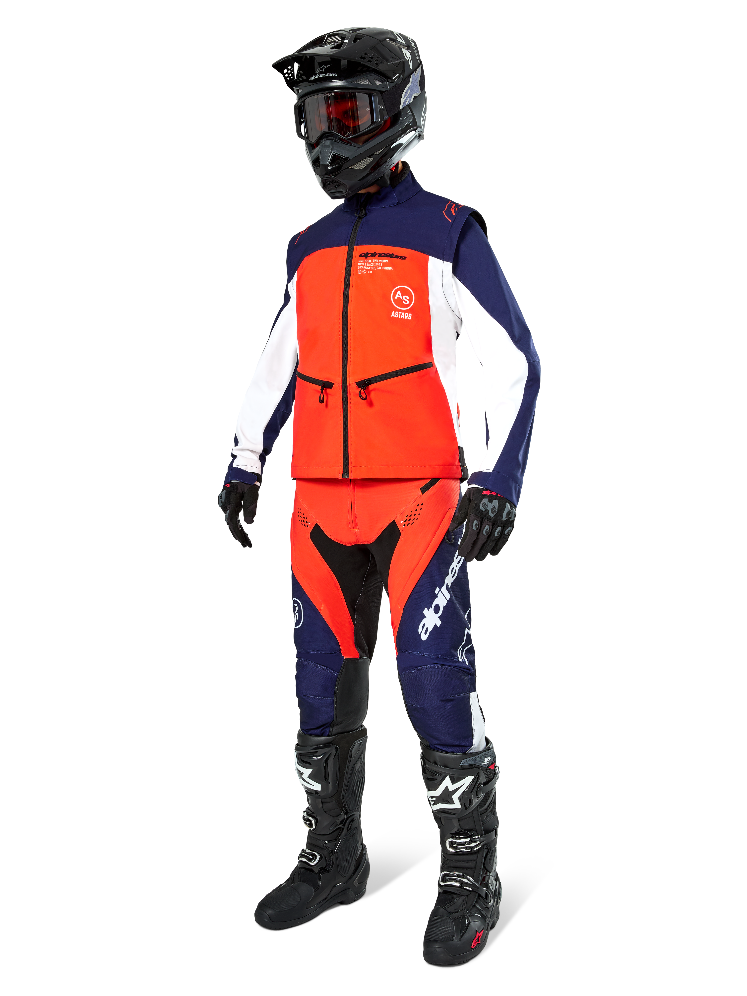 Motorcrossrijder in de Alpinestars Lite-Dura Softshell Jas in Navy Hot Orange en wit, compleet met bijpassende off-road broek, zwarte helm met crossbril en zwarte motorlaarzen, gecoördineerde enduro-uitrustingsset
