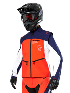 Alpinestars Lite-Dura Softshell Jas in navy, feloranje en wit, motorcross uitrusting, gedragen met zwarte helm en motorbril, beschermende handschoenen en bijpassende racebroek