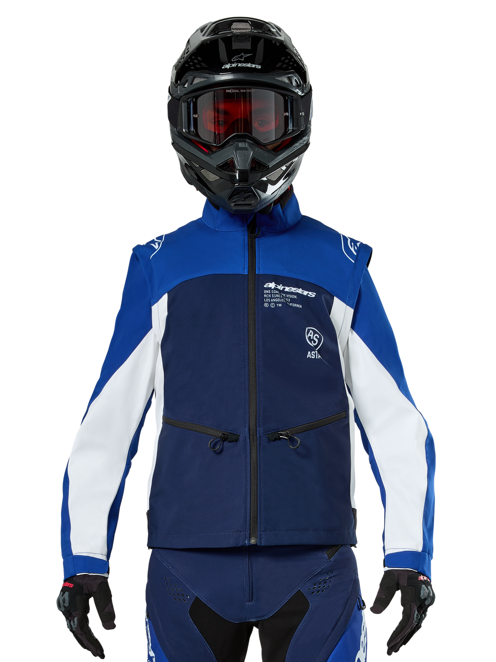 Motocross-rijder met de Alpinestars Lite-Dura Softshell Jas in Navy Bright Blue White, vooraanzicht, gecombineerd met een zwarte helm en een bril met rode glazen, voorzien van een technisch winddicht ontwerp met ritszakken en witte accenten voor off-road enduro rijden