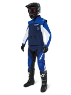 Alpinestars Lite-Dura Softshell Jas, Navy, felblauw en wit, gedragen met bijpassende off-road broek, zwarte motorcrosslaarzen, zwarte helm met crossbril en zwarte handschoenen, complete enduro-uitrusting voor off-road racing