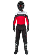 Motocross rider wearing Alpinestars Pro-Dura Pants in Black and Magnet, paired with a red, white, and black jersey, black helmet, and black boots, full off-road racing gear kit, durable and lightweight design for enduro riding